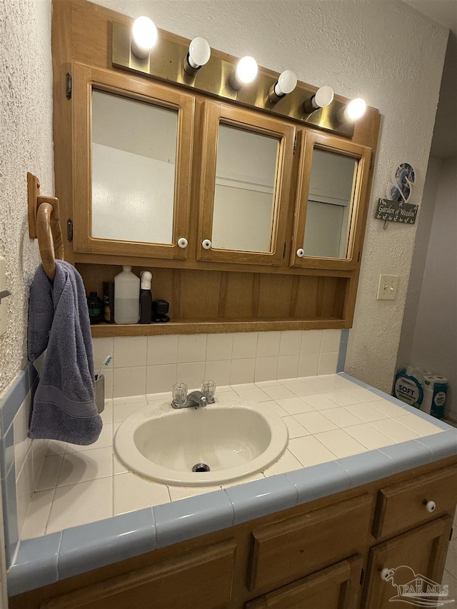 5325 Bob Sikes Blvd, Jay, FL 32565 - bathroom with a textured wall, vanity, and backsplash
