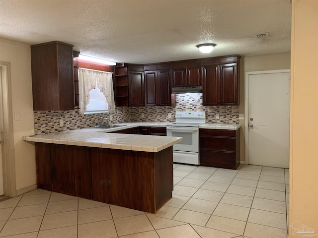 kitchen featuring sink, tile countertops, a textured ceiling, electric range, and kitchen peninsula