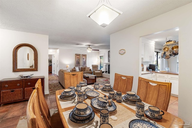 dining space with a textured ceiling, ceiling fan, and light tile patterned floors