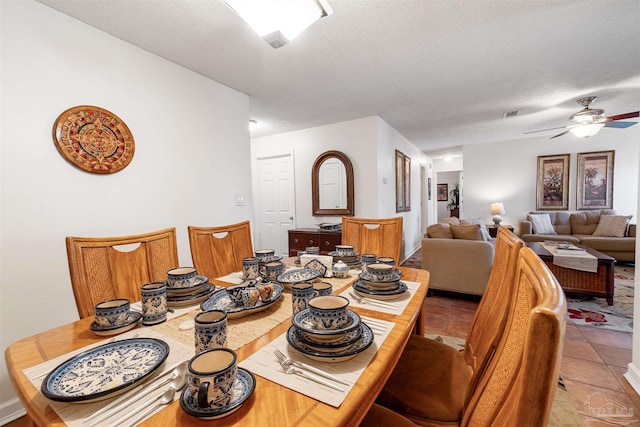 dining area featuring a textured ceiling, ceiling fan, and light tile patterned floors