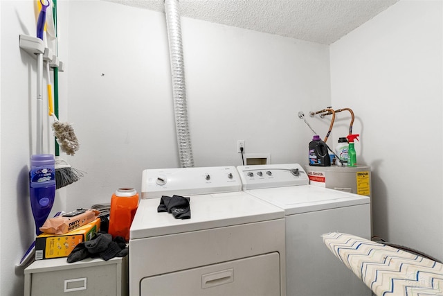 clothes washing area with independent washer and dryer and a textured ceiling