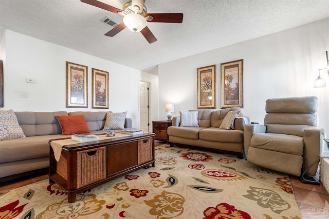 living room with a textured ceiling and ceiling fan