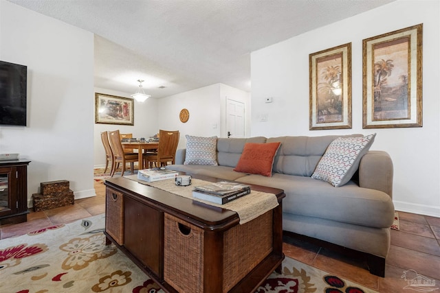 living room with a textured ceiling and light tile patterned floors