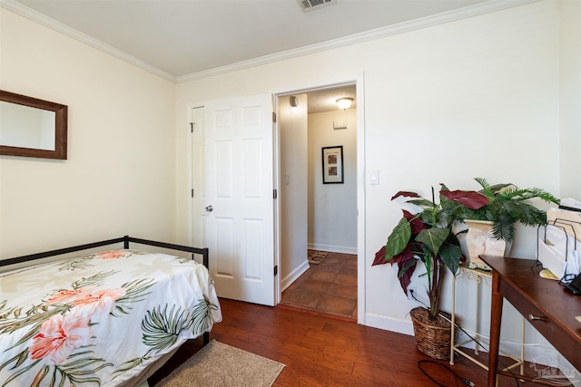 bedroom featuring crown molding and dark hardwood / wood-style floors