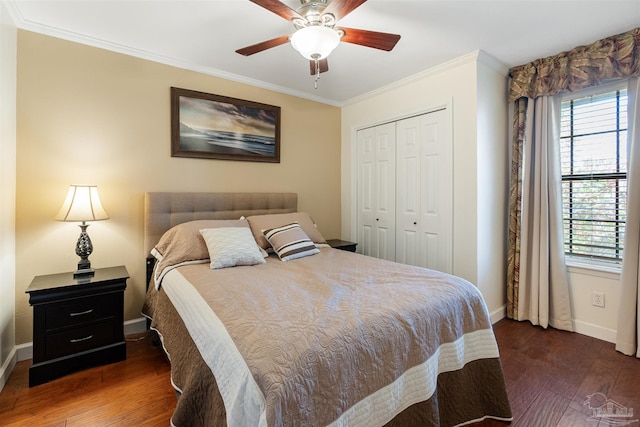 bedroom featuring dark hardwood / wood-style flooring, ornamental molding, ceiling fan, and a closet