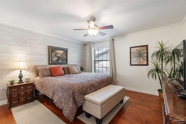 bedroom featuring ornamental molding, dark wood-type flooring, wood walls, and ceiling fan