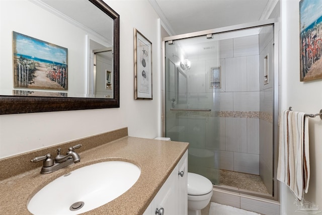 bathroom featuring toilet, a shower with shower door, crown molding, and vanity