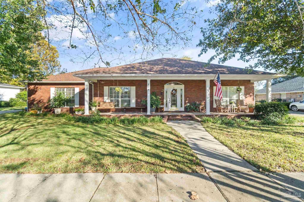 ranch-style home with covered porch and a front lawn