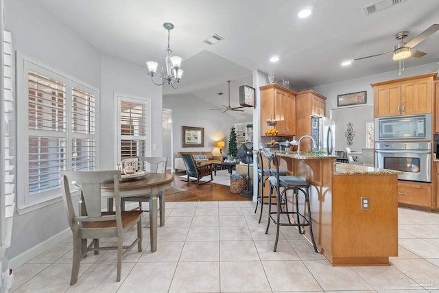 kitchen featuring kitchen peninsula, light stone countertops, plenty of natural light, and appliances with stainless steel finishes