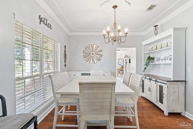 dining area featuring a chandelier, crown molding, and dark wood-type flooring