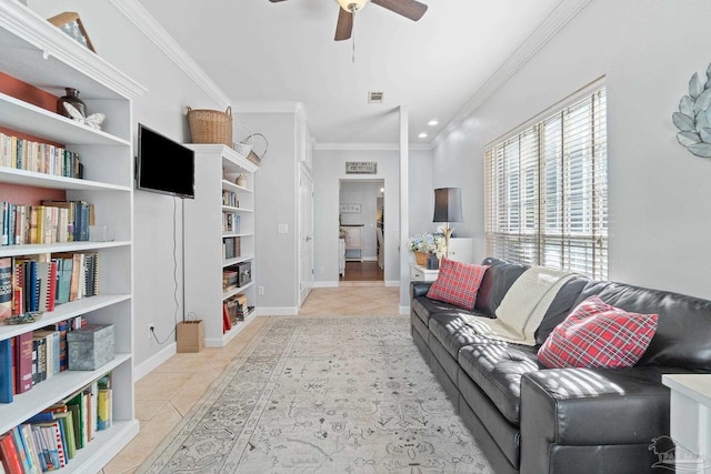 living room with built in shelves, crown molding, light tile patterned floors, and ceiling fan