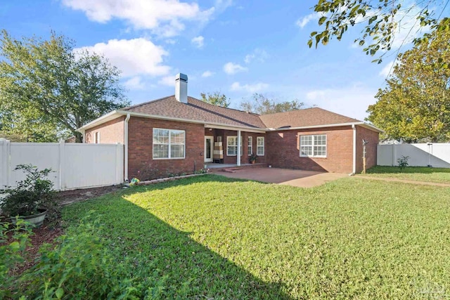 rear view of house featuring a patio area and a lawn