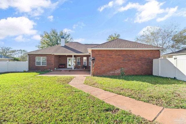 rear view of property with a yard and a patio