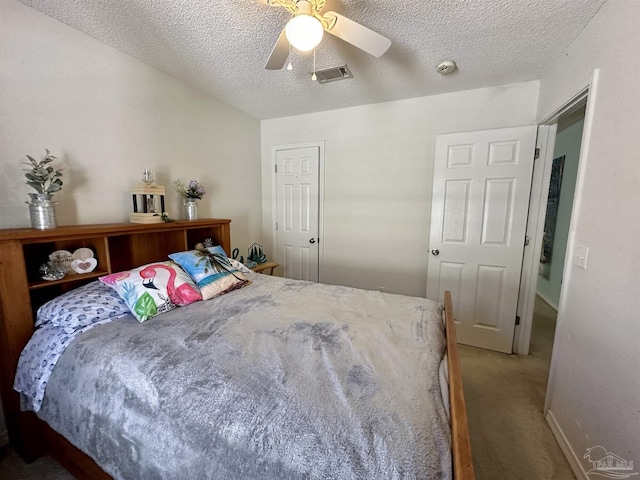 carpeted bedroom featuring a ceiling fan and a textured ceiling