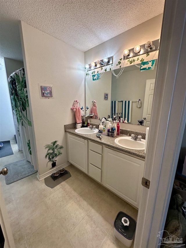 bathroom featuring a textured ceiling and double vanity