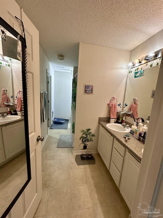 full bathroom featuring two vanities, a textured ceiling, and a shower with shower curtain