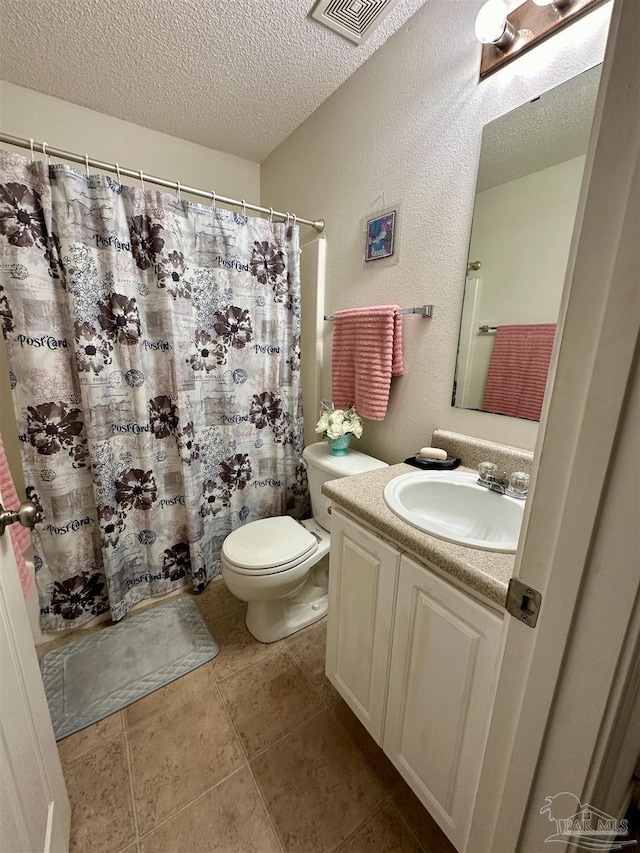 bathroom with a textured ceiling, toilet, vanity, and curtained shower