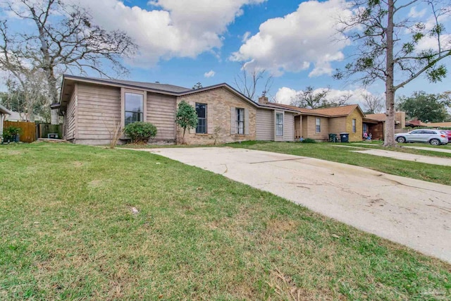 single story home with brick siding, concrete driveway, a front lawn, and fence