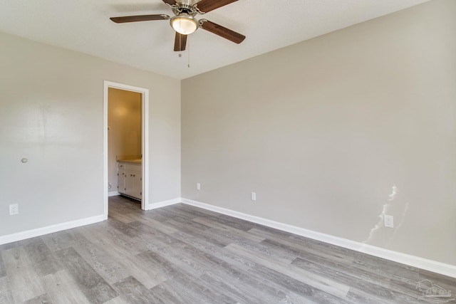 spare room featuring a ceiling fan, baseboards, and wood finished floors