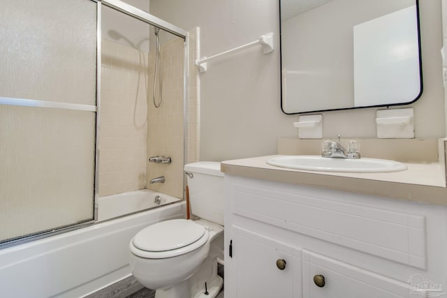 full bath featuring toilet, vanity, and bath / shower combo with glass door