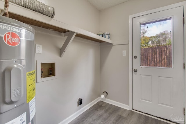 clothes washing area featuring washer hookup, wood finished floors, water heater, baseboards, and laundry area