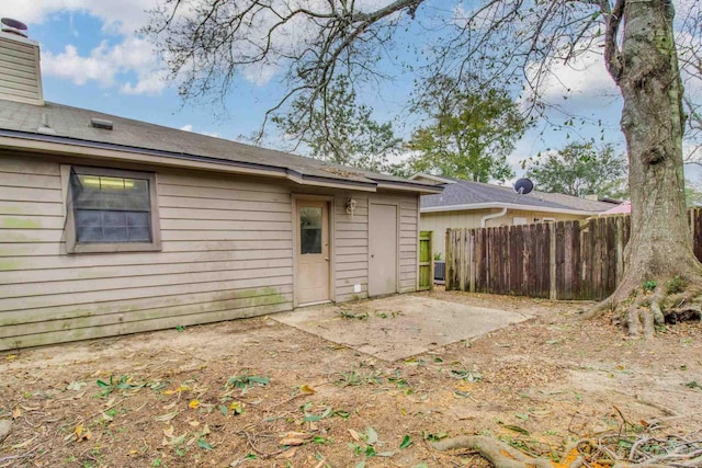 back of property featuring a patio, fence, and a chimney