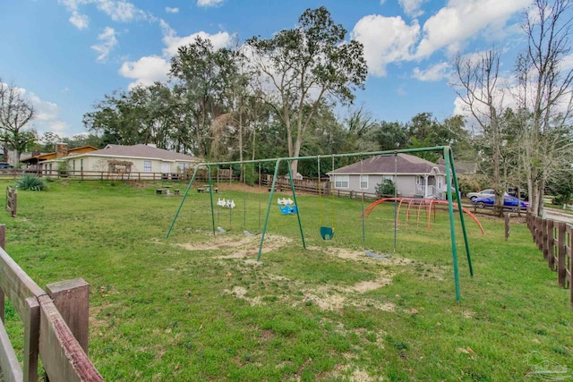 view of yard featuring playground community and fence