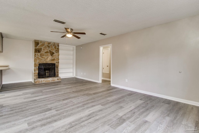 unfurnished living room featuring visible vents, wood finished floors, and a fireplace