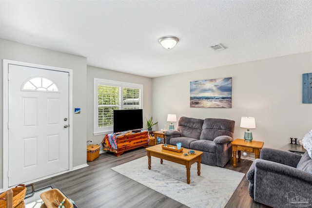 living room featuring dark hardwood / wood-style flooring and a textured ceiling