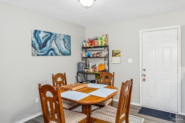 dining room featuring dark hardwood / wood-style flooring and a textured ceiling