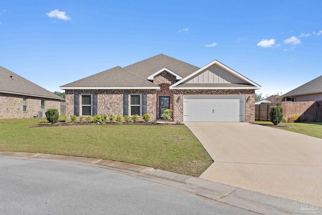 view of front of house with driveway, a front lawn, fence, an attached garage, and brick siding