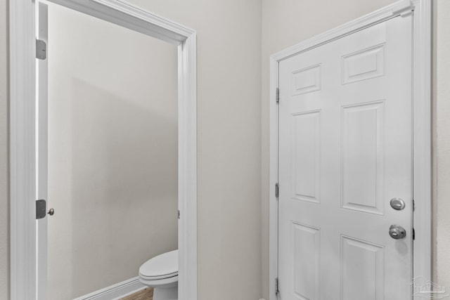 bathroom with baseboards and toilet