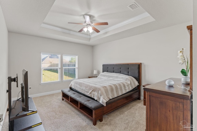 bedroom with visible vents, light carpet, a ceiling fan, baseboards, and a raised ceiling