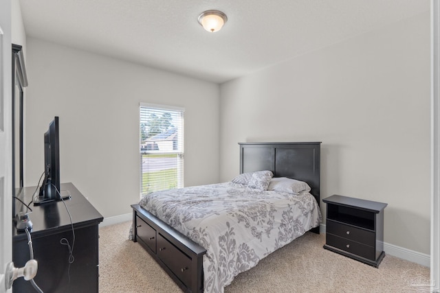 bedroom featuring light colored carpet and baseboards