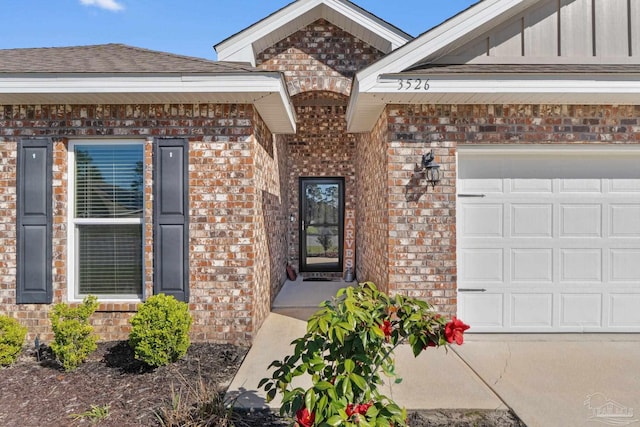 entrance to property with brick siding and a garage