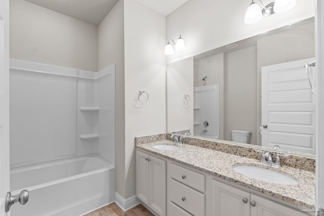 full bathroom featuring shower / washtub combination, toilet, double vanity, and a sink