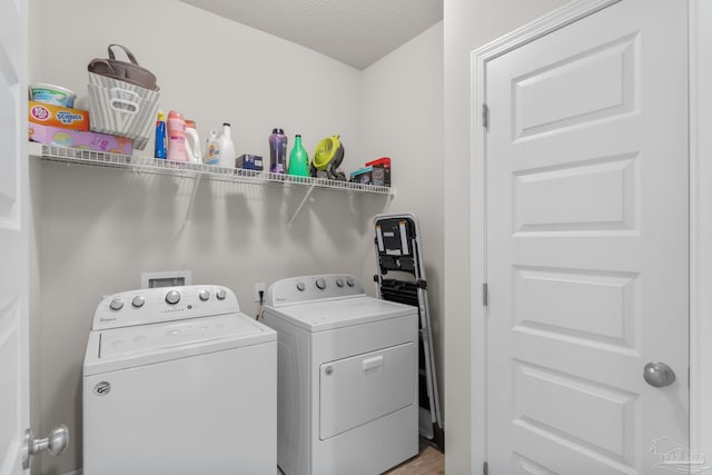 laundry room featuring washer and dryer, a textured ceiling, and laundry area