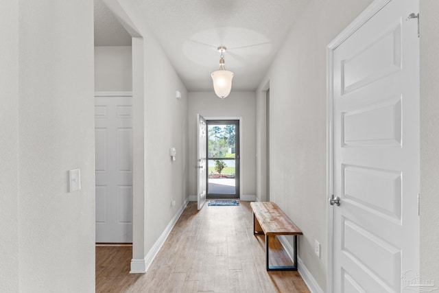 entryway with baseboards and light wood-style flooring