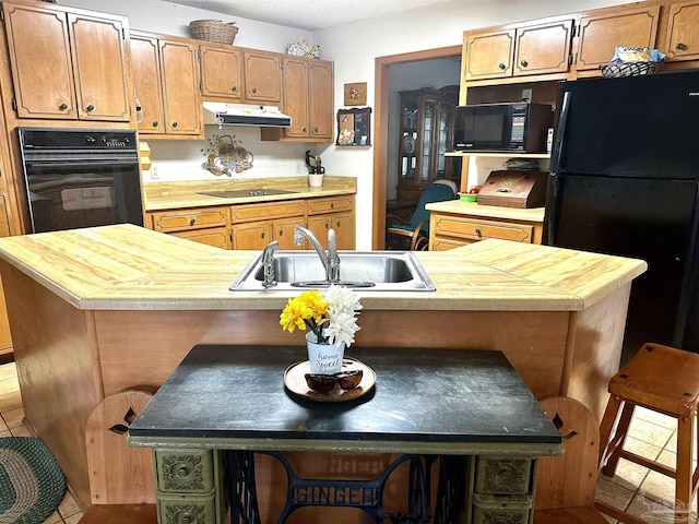 kitchen featuring light tile patterned floors, sink, a kitchen island, and black appliances