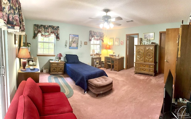 carpeted bedroom featuring ceiling fan, a textured ceiling, and multiple windows