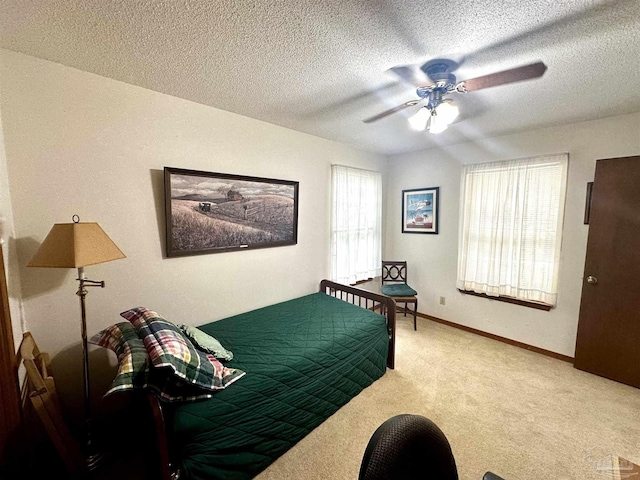 bedroom featuring carpet flooring, a textured ceiling, and ceiling fan