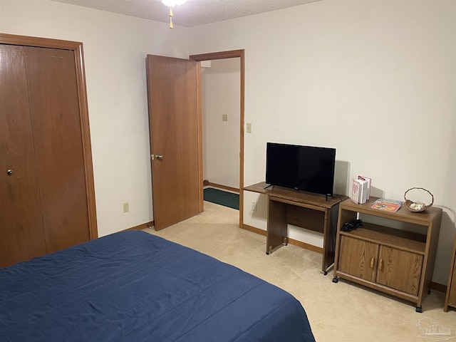 bedroom featuring a closet, light colored carpet, and a textured ceiling