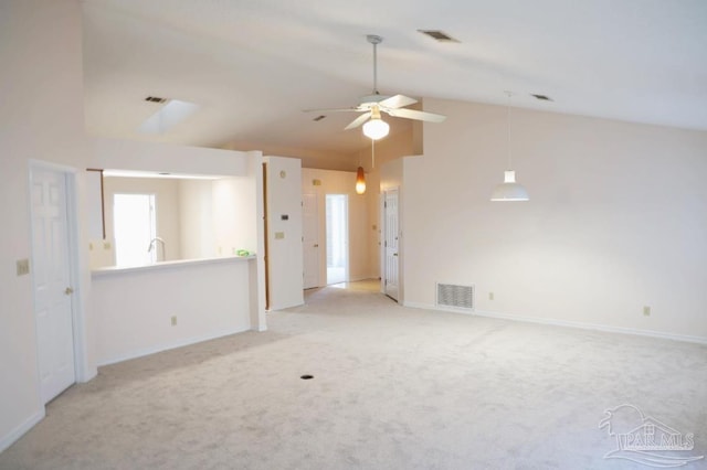 spare room featuring a ceiling fan, lofted ceiling, visible vents, and light carpet