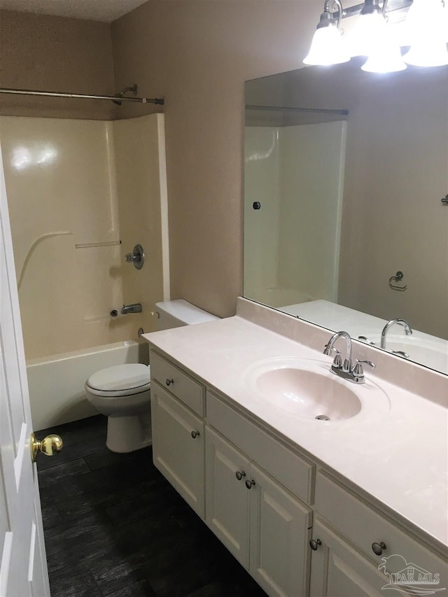 full bathroom featuring vanity, toilet, wood finished floors, and bathtub / shower combination