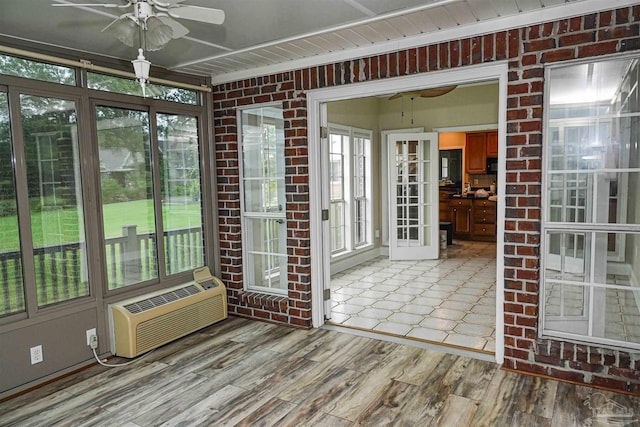 unfurnished sunroom featuring a healthy amount of sunlight and ceiling fan