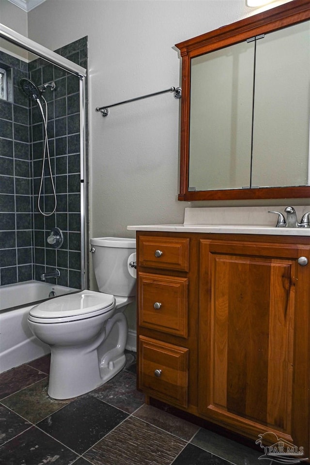 full bathroom with combined bath / shower with glass door, vanity, and toilet