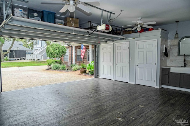 garage with a garage door opener, ceiling fan, and sink