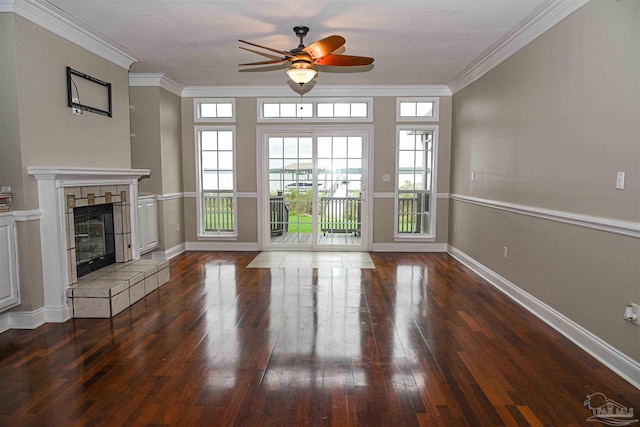 unfurnished living room featuring ornamental molding, ceiling fan, a tile fireplace, and dark hardwood / wood-style flooring