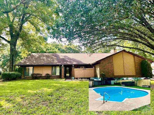 view of pool featuring a lawn