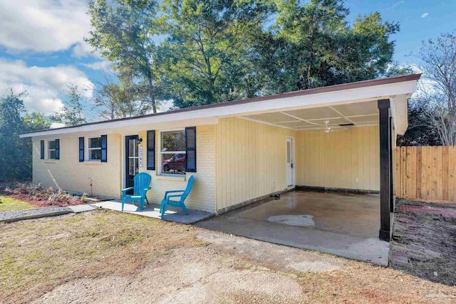 view of front facade with fence, brick siding, an attached carport, and a porch